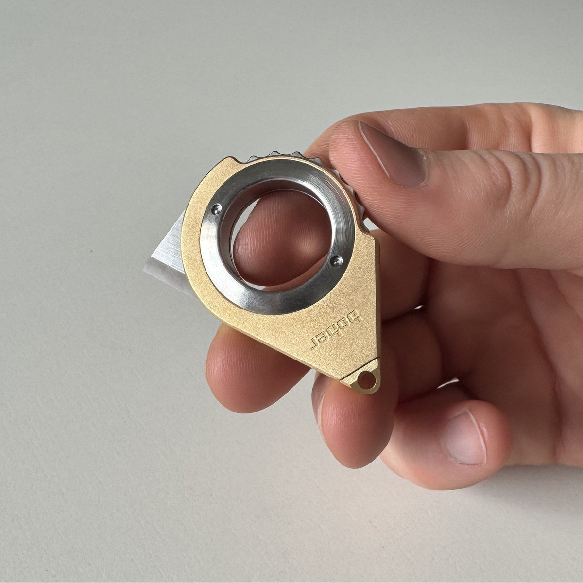 Brass BOBER held between two fingers