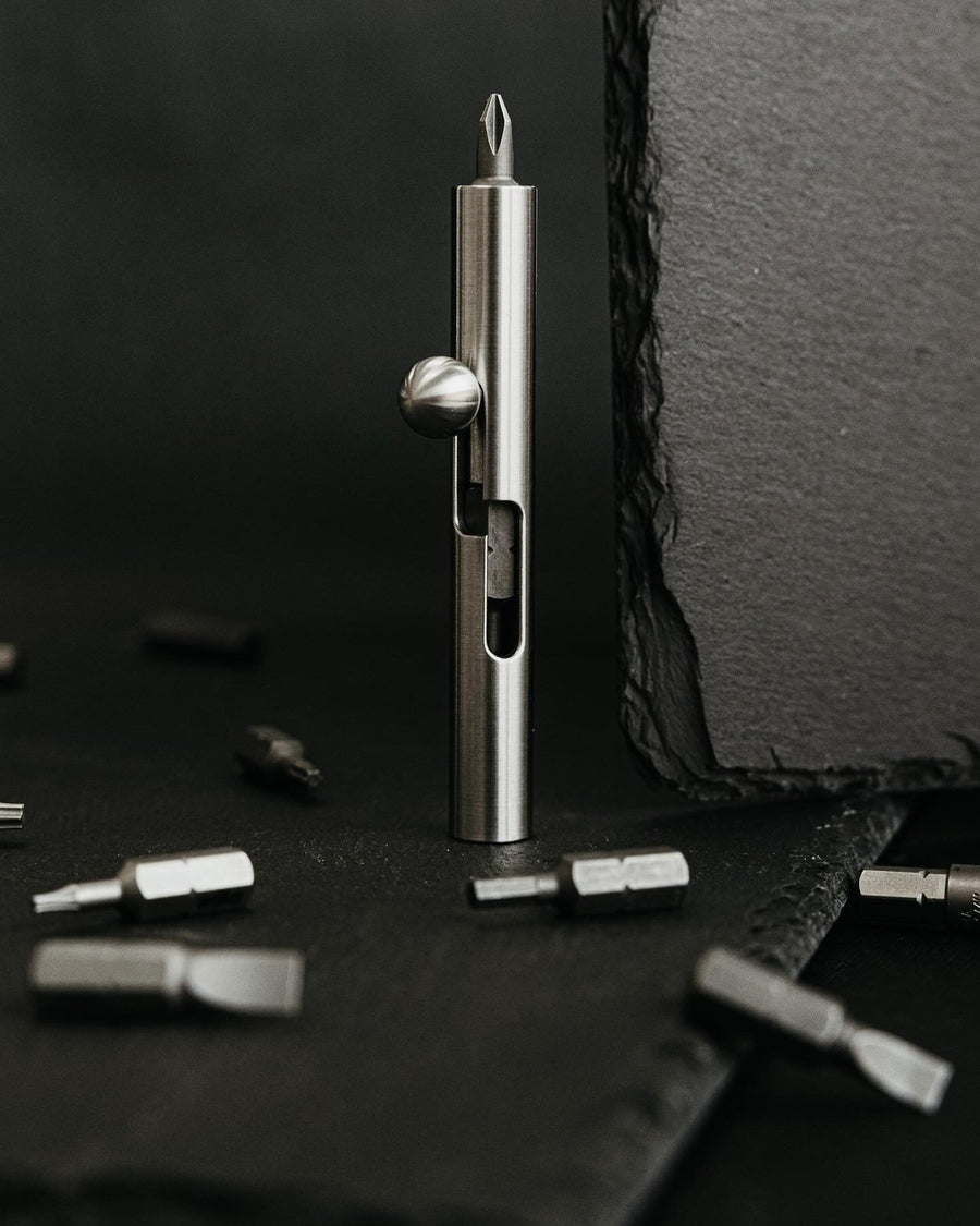 Strikerbit bolt-action screwdriver standing among loose hex bits