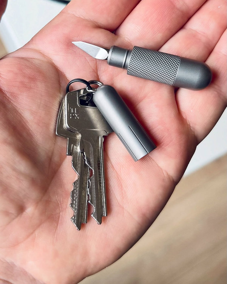 UltraPill blade open in a hand next to keys
